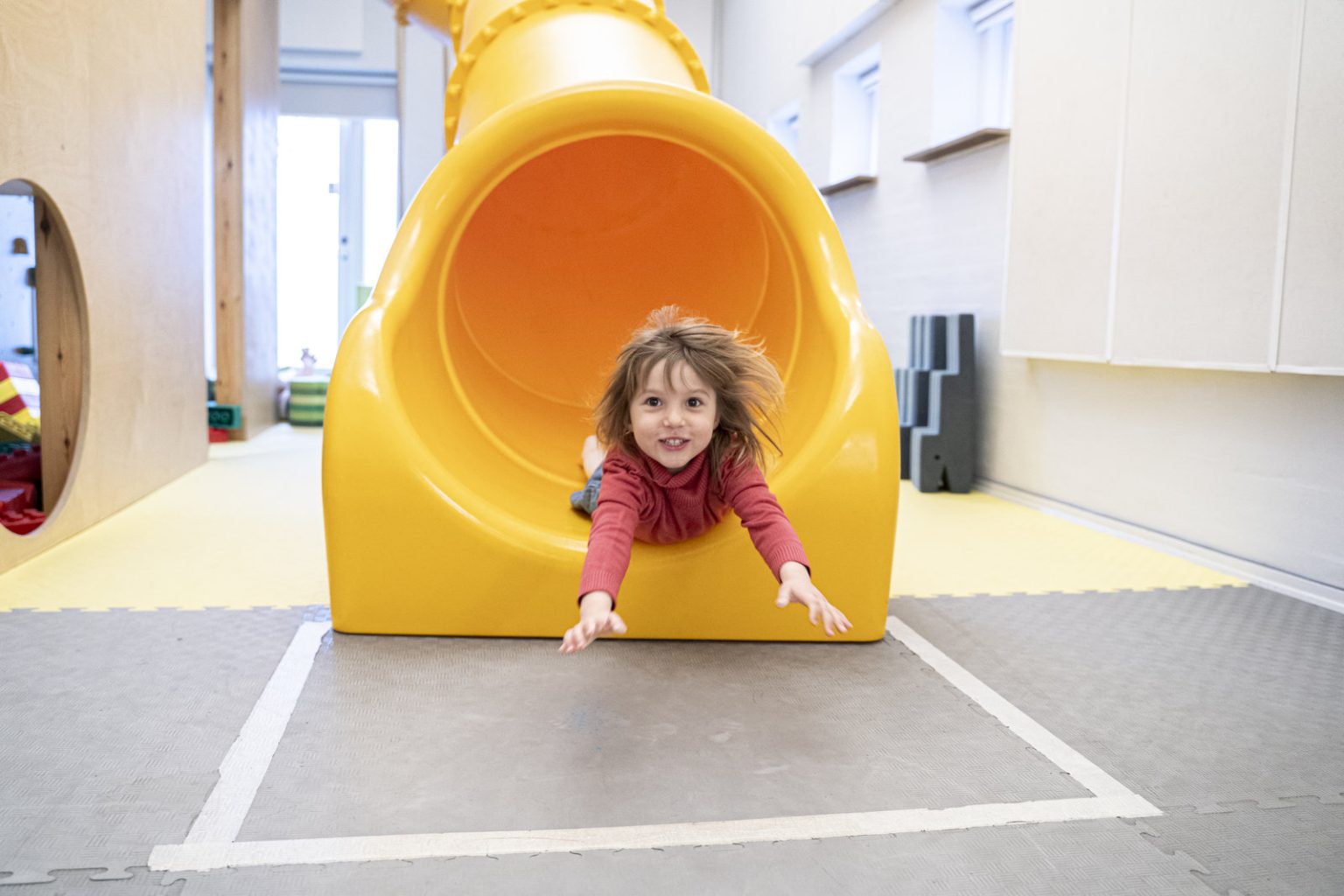 Kindergarten girl on a yellow slide at ISB, Billund, Denmark