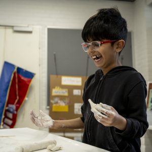 Child making crafts and laughing in Primary School, ISB, Denmark